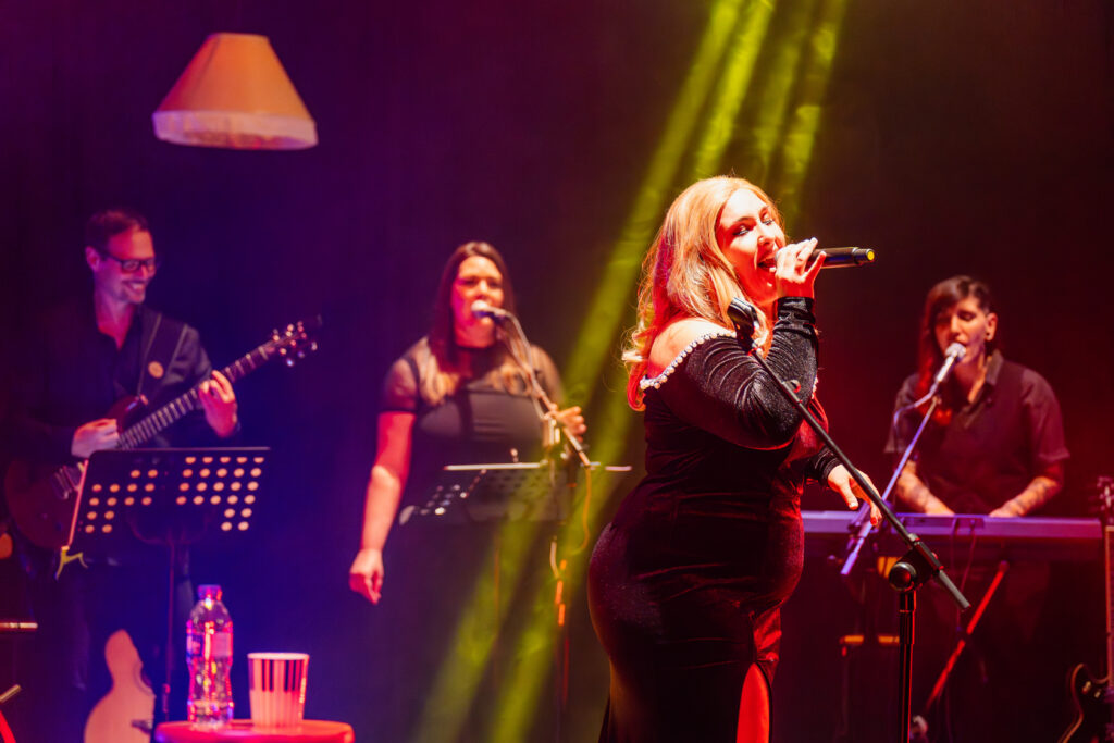 Flavia cantando fondo guitarra y coristas